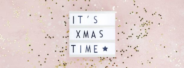 New Year or Christmas composition flat lay top view Xmas holiday celebration handmade handicraft wooden garland with text pink background copy space Template for greeting card text design - Photo, Image