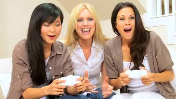 Kolme monikansallista naista pelaamassa elektronisia pelejä
 - Materiaali, video