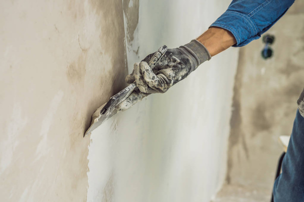 Hand of master applying finishing putty on wall. - Foto, afbeelding
