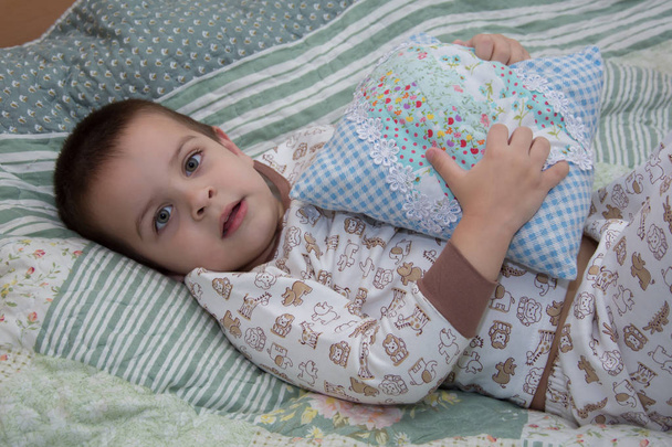 ένα παιδί πηδά σε ένα κρεβάτι, συναισθήματα σε ένα πρόσωπο s παιδί - Φωτογραφία, εικόνα