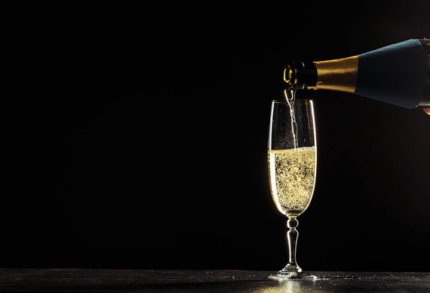 bottle of champagne and glasses over dark background - Fotoğraf, Görsel