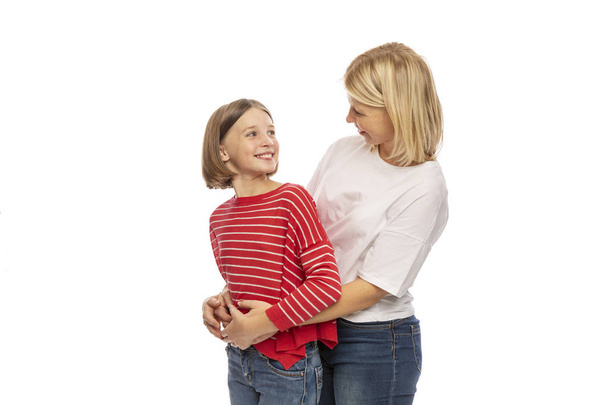 Mom and teen daughter embrace and laugh, isolated on white background - Foto, imagen