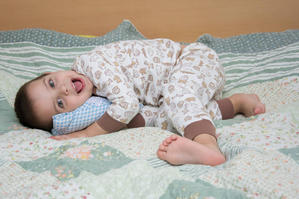 uma criança pula em uma cama, emoções na cara de uma criança
 - Foto, Imagem