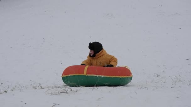 冬の雪の楽しみ。子供のスライド チューブに乗る. - 映像、動画