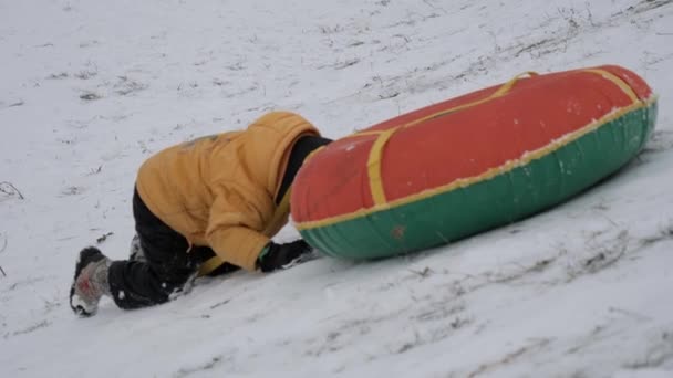 divertimento neve invernale. i bambini cavalcano un tubo da uno scivolo
. - Filmati, video