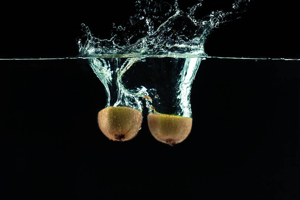 Splashing kiwi fruit on the water - Fotoğraf, Görsel