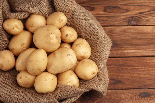 Pile of potatoes lying on wooden boards - Zdjęcie, obraz