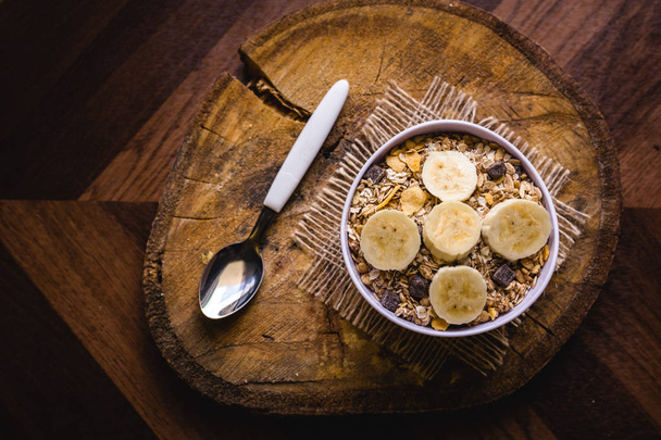 Cereal, seeds and oats, and banana slices, a healthy meal for breakfast or afternoon snack. - Фото, зображення