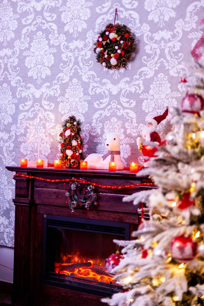 Decorated Christmas tree in front of the fireplace with various candles. - Photo, Image