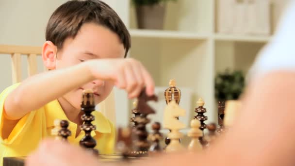 Nuori valkoihoinen poika pelaa shakkia peli
 - Materiaali, video
