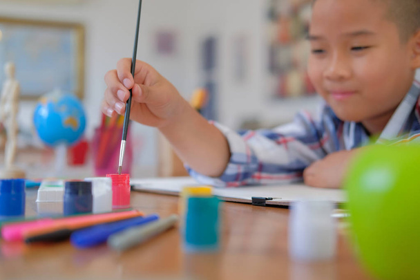 pouco asiático garoto menino criança estudante segurando pintura pincel desenho pintura aquarela. crianças atividade de lazer em casa
 - Foto, Imagem