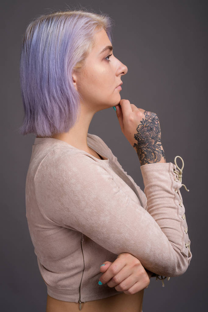 Joven hermosa mujer rebelde con el pelo colorido contra la espalda gris
 - Foto, imagen