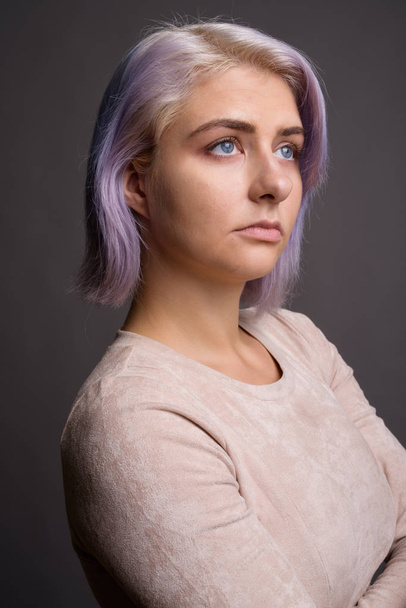 Young beautiful rebel woman with colorful hair against gray back - Fotografie, Obrázek