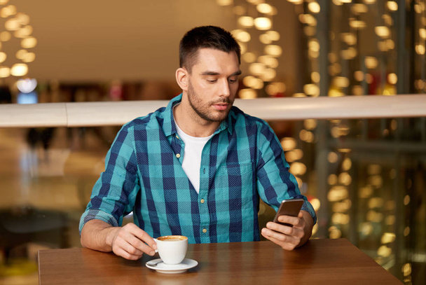 ember, kávé és smartphone étteremben - Fotó, kép