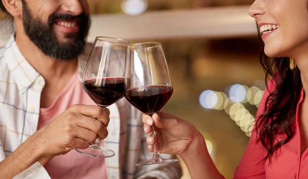 happy couple drinking red wine at restaurant - Zdjęcie, obraz