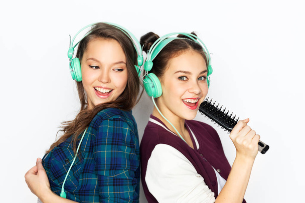 teenage girls in earphones listening to music - Valokuva, kuva