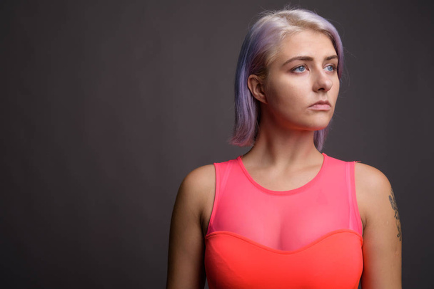 Young beautiful rebel woman with colorful hair against gray back - Foto, afbeelding