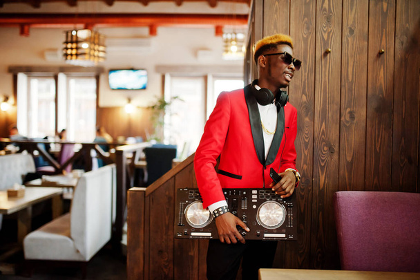 Мода афроамериканський чоловік модель DJ на червоному костюмі з контролером DJ
.  - Фото, зображення