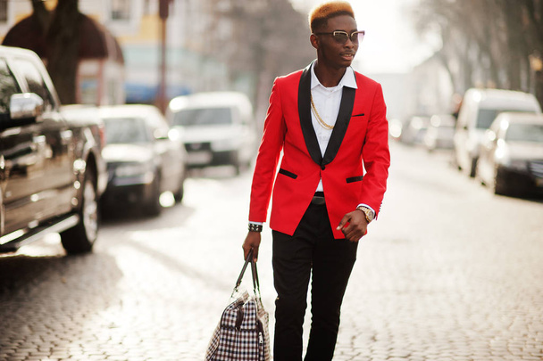 Fashion african american man model at red suit, with highlights hair and handbag posed at street. - Zdjęcie, obraz