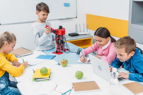 Školáci psaní, používání notebooku, pracuje na robota na lekci o robotice kmenových - Fotografie, Obrázek