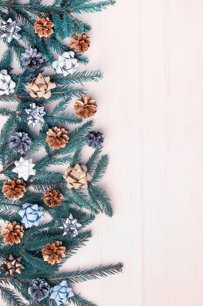 Рождественская композиция еловых ветвей, украшенных луками и сосновыми шишками
 - Фото, изображение