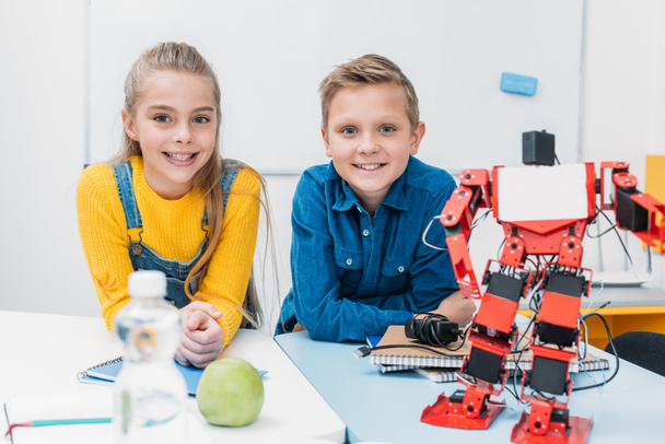 schoolboy and schoolgirl looking at camera and smiling in stem education class - Photo, image