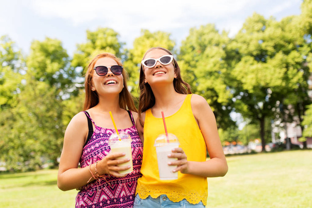 девушки-подростки с молочными коктейлями в летнем парке
 - Фото, изображение