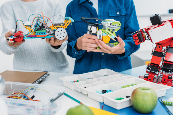 cropped view of schoolboys holding handmade robots in stem class - Foto, Imagem