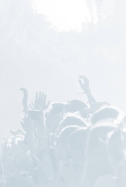 Menigte toeschouwers tijdens een concert in licht blauw tonaliteit. Hoge belangrijke achtergrond met een volk op een open speelplaats tijdens een concert. Abstracte Softfocus afbeelding met kopie ruimte - Foto, afbeelding
