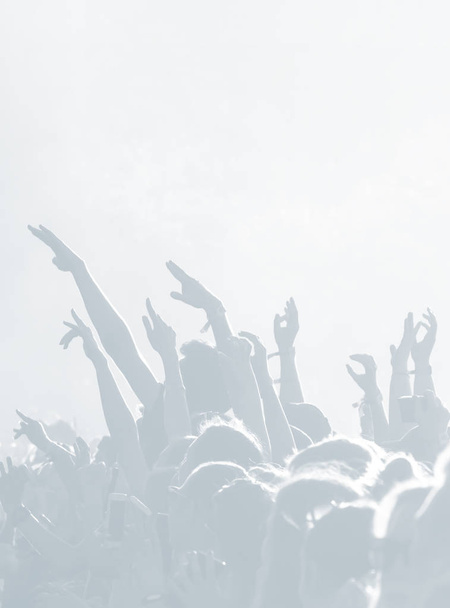 Zuschauermenge bei einem Konzert in hellblauer Tonalität. High Key Hintergrund mit einem Volk auf einem offenen Spielplatz bei einem Konzert. abstraktes Weichzeichner-Bild mit Kopierraum - Foto, Bild