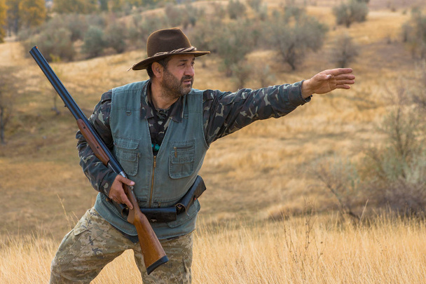 Chasseur avec un chapeau et une arme à feu à la recherche de proies dans la steppe, Vise la proie
 - Photo, image