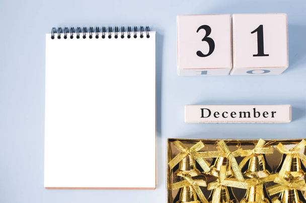 Απομονωμένη σημειωματάριο με κουδούνια και ένα ημερολόγιο 31 Δεκεμβρίου. - Φωτογραφία, εικόνα