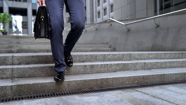 Businessman walking downstairs holding briefcase, going to important meeting - Foto, immagini