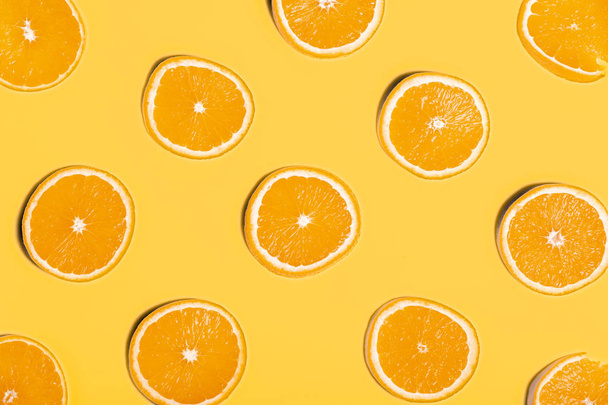 Slices of orange on yellow background - Photo, Image