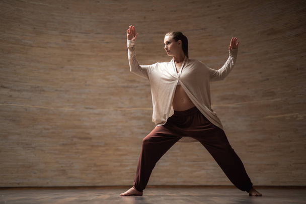 Serious lady practicing chi gong and putting her hands up - Photo, Image