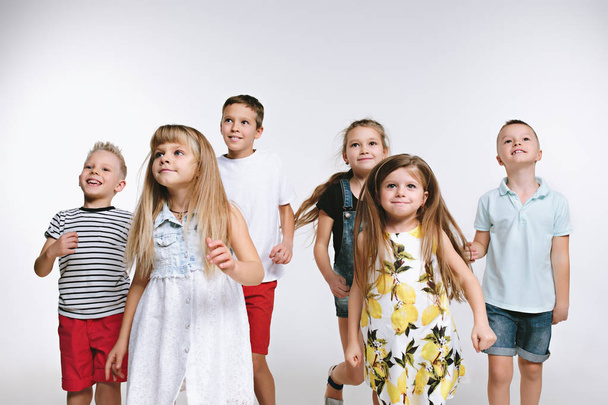Групова мода милий дошкільник діти друзі позують разом і дивляться на білий фон камери
 - Фото, зображення