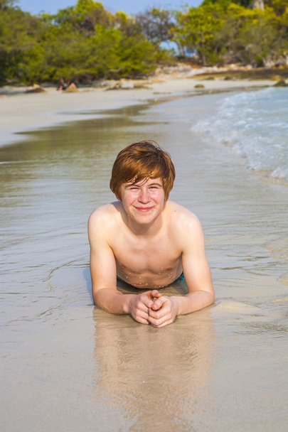 Счастливый мальчик с рыжими волосами наслаждается прекрасным пляжем
 - Фото, изображение