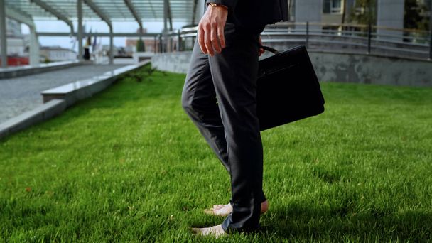 Barefoot employee standing on grass, relaxation after stressful working day - Foto, immagini