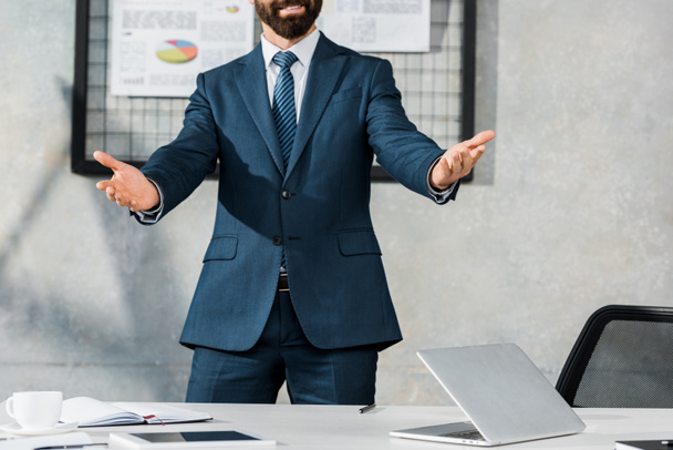 cropped image of businessman gesturing and standing with open arms in office - Photo, Image