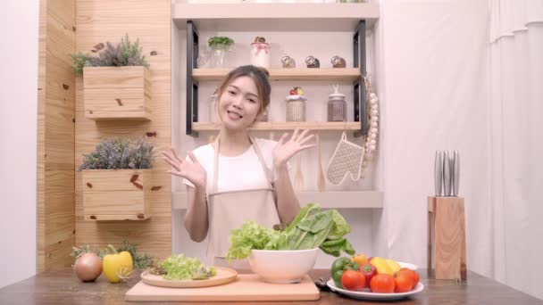 Blogger donna asiatica utilizzando fotocamera registrazione come fare insalata video cibo sano per il suo abbonato, le verdure biologiche uso femminile preparazione insalata per il corpo in forma a casa. Concetto di cibo sano
. - Filmati, video