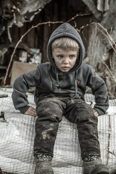 sad homeless boy in abandoned village - Foto, afbeelding