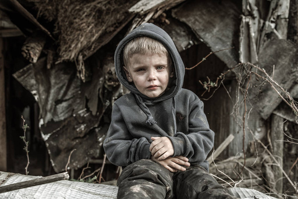 sad homeless boy in abandoned village - Foto, imagen