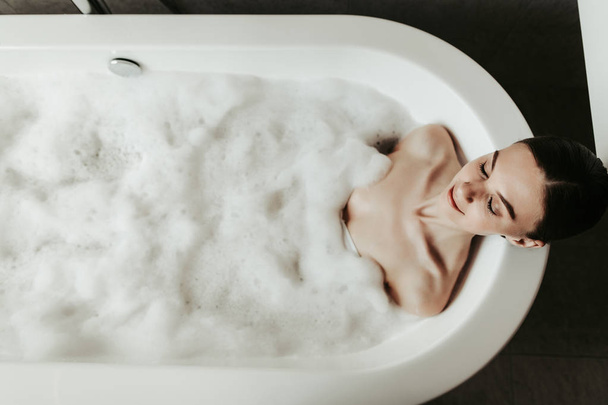 Beautiful young lady taking chill-out bubble bath - Photo, image