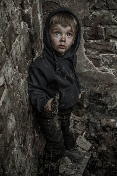 homeless dirty boy with gun in abandoned building - Φωτογραφία, εικόνα