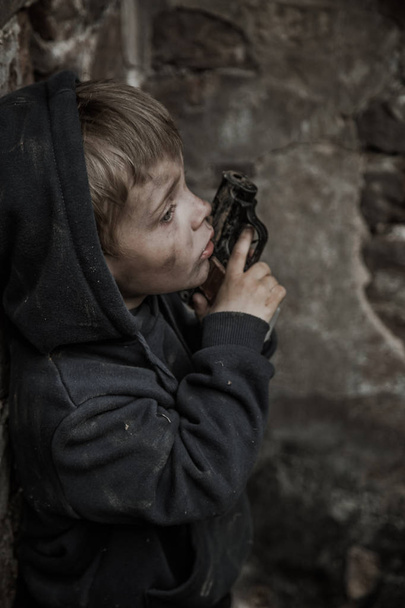 homeless dirty boy with gun in abandoned building - Valokuva, kuva