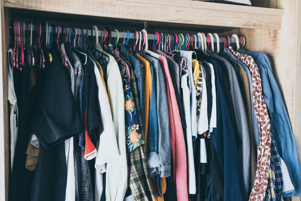Hangers with different clothes in wardrobe closet - vintage light filter - Fotografie, Obrázek