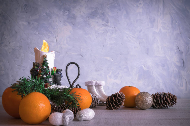 Christmas or New Year composition with a candle, tangerines, and Christmas decorations, pine cones, a place for text. holiday composition of the new year. postcard. - Fotó, kép