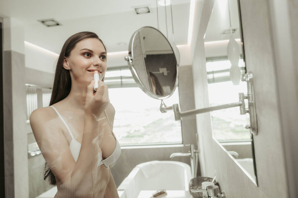 Ευτυχισμένη γυναίκα εφαρμογή make up στο δωμάτιο - Φωτογραφία, εικόνα