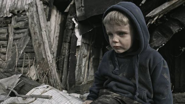 sad homeless orphan kid crying beside abandoned building - Foto, afbeelding