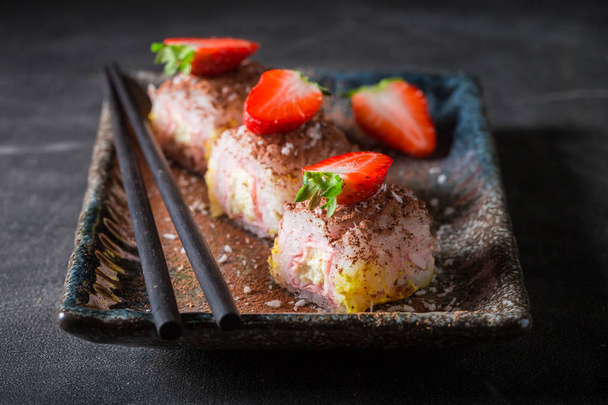 Tasty sweet sushi with cinnamon and chocolate on concrete table - Фото, зображення